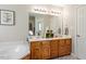 Bathroom with double sink vanity, bathtub, and ample lighting at 53 Stafford Cir, Clayton, NC 27527