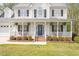 Inviting covered front porch with white railing, hanging plants, and a decorative front door at 53 Stafford Cir, Clayton, NC 27527