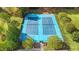 Brightly painted blue tennis courts surrounded by lush trees in a well-maintained community at 53 Stafford Cir, Clayton, NC 27527