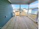 Inviting back porch with wood floors and white railing overlooking a well-manicured lawn at 555 Vine Pkwy, Pittsboro, NC 27312