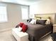 Comfortable bedroom boasts neutral tones, ample natural light from two windows, and a decorative bench at 555 Vine Pkwy, Pittsboro, NC 27312