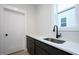 Convenient laundry area with sleek countertops, sink, and storage at 555 Vine Pkwy, Pittsboro, NC 27312