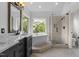 Luxurious bathroom featuring a soaking tub, separate glass-enclosed shower, and elegant vanity with marble countertop at 6209 Remington Lake Dr, Raleigh, NC 27616