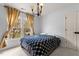 Cozy bedroom featuring a large window with natural light, complemented by a stylish chandelier and comfortable bed at 6209 Remington Lake Dr, Raleigh, NC 27616