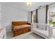 Bedroom features wood daybed and a white crib under bright windows with views of the outdoors at 6209 Remington Lake Dr, Raleigh, NC 27616
