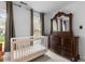 Bedroom features a white crib and dark wood dresser with a decorative mirror, bright windows at 6209 Remington Lake Dr, Raleigh, NC 27616