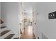 Inviting hallway leading to a bright kitchen area with hardwood flooring and neutral decor at 6209 Remington Lake Dr, Raleigh, NC 27616