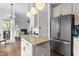Open kitchen layout with granite island, stainless fridge, and seamless flow to the living area at 6209 Remington Lake Dr, Raleigh, NC 27616