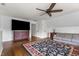 Living room features a ceiling fan, wood dresser, hardwood flooring and large rug at 6209 Remington Lake Dr, Raleigh, NC 27616