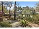 Exterior backyard with windows, lush landscaping, trees, and gravel pathway at 6719 Falconbridge Rd, Chapel Hill, NC 27517