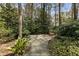 A gravel seating area nestled among trees and foliage in the backyard at 6719 Falconbridge Rd, Chapel Hill, NC 27517