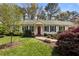 Attractive home featuring classic shutters, a red front door, and lush, manicured landscaping at 6719 Falconbridge Rd, Chapel Hill, NC 27517