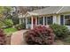 Charming home featuring a bright red front door, classic shutters, and lush landscaping at 6719 Falconbridge Rd, Chapel Hill, NC 27517