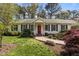 Inviting home featuring a red front door, traditional shutters, and well-kept lawn at 6719 Falconbridge Rd, Chapel Hill, NC 27517