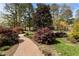 Landscaped front yard featuring a brick walkway and lush, colorful plantings at 6719 Falconbridge Rd, Chapel Hill, NC 27517