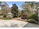 A front yard landscaped with flowering trees, shrubs, and a brick walkway to the house at 6719 Falconbridge Rd, Chapel Hill, NC 27517