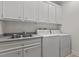 Practical laundry room with utility sink, countertops, and modern washer and dryer at 6719 Falconbridge Rd, Chapel Hill, NC 27517
