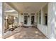 Covered patio featuring a brick floor, ceiling fan, and views of the surrounding landscape at 6719 Falconbridge Rd, Chapel Hill, NC 27517