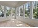 Sunroom with tile flooring surrounded by many windows with backyard views at 6719 Falconbridge Rd, Chapel Hill, NC 27517