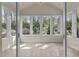 Bright sunroom with tile flooring and views of the private wooded backyard at 6719 Falconbridge Rd, Chapel Hill, NC 27517