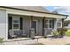 Charming front porch area with stone pillars, seating, and lovely landscaping details at 676 Wall Rd, Wendell, NC 27591