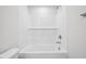Bathroom featuring a white tiled shower-tub combination with a built-in shelf and modern fixtures at 700 Deschutes Dr, Garner, NC 27529