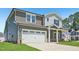 An eye-level exterior view of a two-story home, with a two car garage, manicured lawn, and inviting architecture at 700 Deschutes Dr, Garner, NC 27529