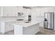 Bright modern kitchen with white cabinets, stainless steel appliances, and a central island for food preparation and dining at 700 Deschutes Dr, Garner, NC 27529