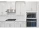 New stainless steel microwave, stove, oven, and backsplash in modern kitchen with white cabinets and quartz countertops at 700 Deschutes Dr, Garner, NC 27529