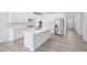 Contemporary kitchen with white cabinetry, stainless steel appliances, and an island with a sink and counter seating at 700 Deschutes Dr, Garner, NC 27529