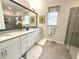 Bright bathroom with double sink vanity, large mirror, and glass shower at 7125 Crested Iris Pl, Durham, NC 27703