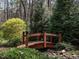 Charming backyard bridge surrounded by lush greenery, creating a serene and picturesque landscape feature at 7312 Ridgeline Dr, Raleigh, NC 27613