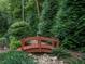 Charming backyard bridge surrounded by lush greenery, creating a serene and picturesque landscape feature at 7312 Ridgeline Dr, Raleigh, NC 27613