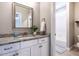 Bathroom with white cabinets, gray granite countertop, modern fixtures, and shower over the tub at 7312 Ridgeline Dr, Raleigh, NC 27613