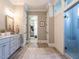 Elegant bathroom featuring double vanities, a walk-in closet, and a modern glass-enclosed shower at 7312 Ridgeline Dr, Raleigh, NC 27613