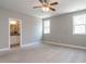 Bedroom featuring ensuite bathroom access, neutral walls, carpet flooring, and windows for natural light at 7312 Ridgeline Dr, Raleigh, NC 27613