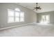 Spacious bedroom features a ceiling fan, plush carpet, and large window with abundant natural light at 7312 Ridgeline Dr, Raleigh, NC 27613
