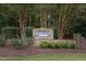 Stone entrance sign to Highland Forest with lush trees, landscaping, and foliage creating a welcoming, established feel at 7312 Ridgeline Dr, Raleigh, NC 27613