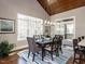 A dining room features a table with seating for six, a vaulted ceiling, a large window, and access to the patio at 7312 Ridgeline Dr, Raleigh, NC 27613