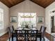A dining room features a table with seating for six, a vaulted ceiling, and a large window at 7312 Ridgeline Dr, Raleigh, NC 27613