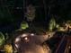 Elevated view of a stone fire pit surrounded by landscaping with seat wall and lights at 7312 Ridgeline Dr, Raleigh, NC 27613