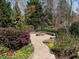 Outdoor stone fire pit with a surrounding patio and landscaped gardens, perfect for entertaining friends and Gathering outdoors at 7312 Ridgeline Dr, Raleigh, NC 27613