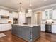 A kitchen features granite countertops, white cabinets, stainless steel appliances, hardwood floors, and a wine cooler at 7312 Ridgeline Dr, Raleigh, NC 27613