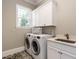 Functional laundry room equipped with washer, dryer, sink, and ample cabinet space for storage at 7312 Ridgeline Dr, Raleigh, NC 27613
