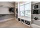 Organized walk-in closet with built-in shelving, hanging rods, and a window bench for storage at 7312 Ridgeline Dr, Raleigh, NC 27613