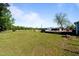 Sprawling backyard with green grass, play set, and deck, perfect for outdoor enjoyment and entertaining at 8211 Julian Rd, Dunn, NC 28334