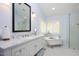 Bright bathroom featuring a vanity with marble countertop, soaking tub and a separate glass enclosed shower at 8508 Kayenta Ct, Wake Forest, NC 27587