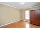 Clean bedroom offers hardwood floor, a window and a dark wood armoire in a neutral color palette at 8508 Kayenta Ct, Wake Forest, NC 27587