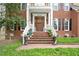 Stunning brick home's entrance featuring a covered front porch with rocking chairs and beautiful landscaping at 8508 Kayenta Ct, Wake Forest, NC 27587