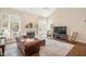 Bright living room with hardwood floors, a fireplace, and large windows providing ample natural light at 8508 Kayenta Ct, Wake Forest, NC 27587